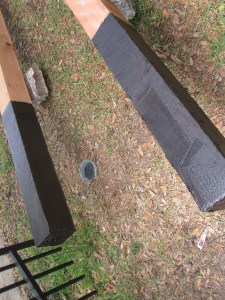 We coat the cedar posts with roofing tar before setting them in with cement.