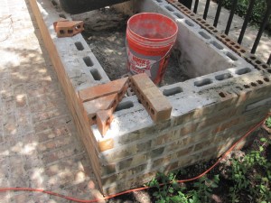 The raised vegetable and herb bed is made of slender cinder blocks so we could face it in brick.