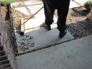 Installing rainbow gravel between cement pads.