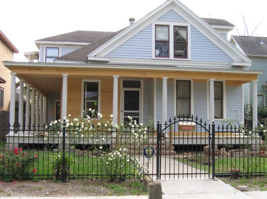 Here is an old picture with the roses and the wrought iron fence. New porch construction in background. 