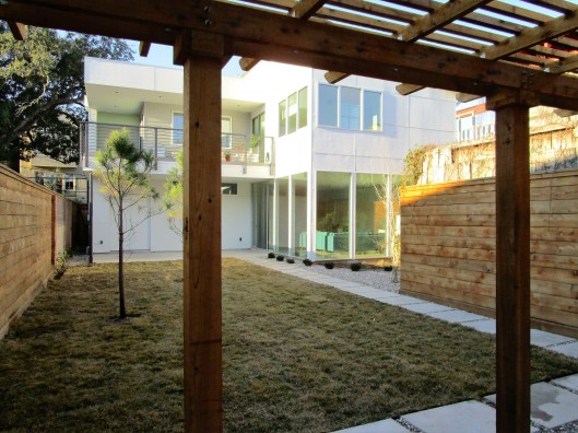 Pergola, lawn and pine trees.